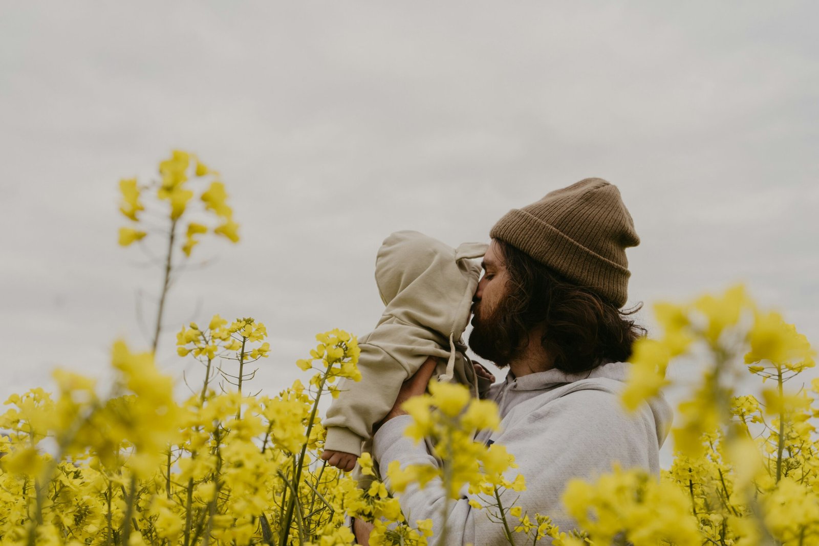 a man and woman kissing in a field of yellow flowers